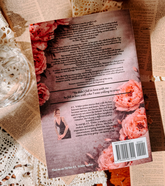 Book titled 'Ruin Me Softly' by A.L. Wilder on a table with a candle and flowers.
