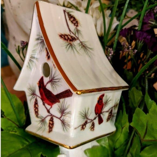 Decorative night light shaped like a birdhouse with a red cardinal design on a plain background