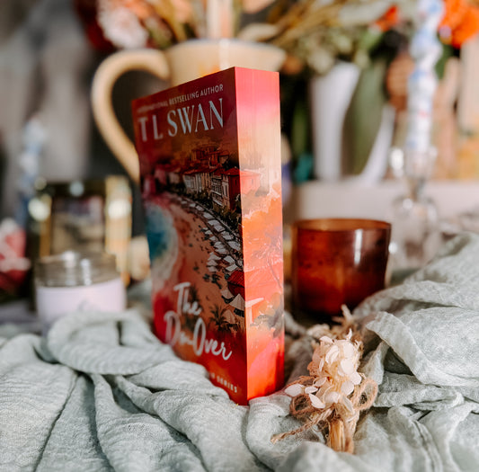 Book titled 'The Do-Over' by T.L. Swan on a soft surface with a candle and cup.