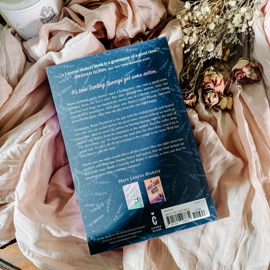 Book titled 'It Seemed Like a Good Idea' by Lauren Blakely on a soft fabric background with flowers.