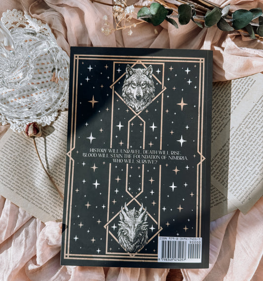 Book titled 'Blood Rains Down' with decorative elements on a soft fabric background