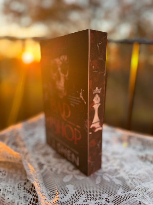 Book titled 'Bad Bishop' by L.J. Shen on a lace surface