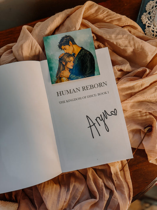 Book titled 'Human Reborn' by Aryn Eleven Shaw on a soft fabric background