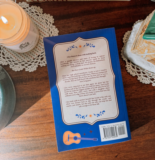 Book titled 'After the Rain' by Amber Palmer on a wooden surface with decorative elements.