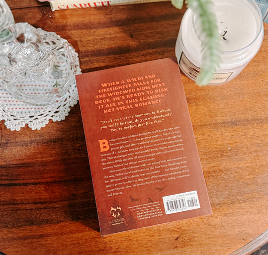 Book titled 'Honor' by Danielle Baker on a wooden surface with decorative items.