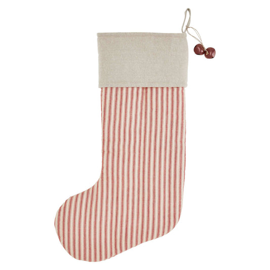 Christmas stocking hanging on a white fireplace with decorative elements.