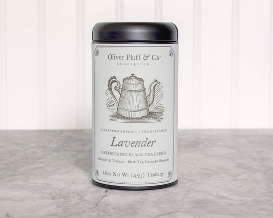 Tea canister labeled 'Oliver Pluff & Co' with a tea bag on a wooden surface. Lavender