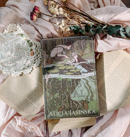 Book titled 'This Fatal Kiss' by Alicia Jasińska on an open book with floral and lace decorations.