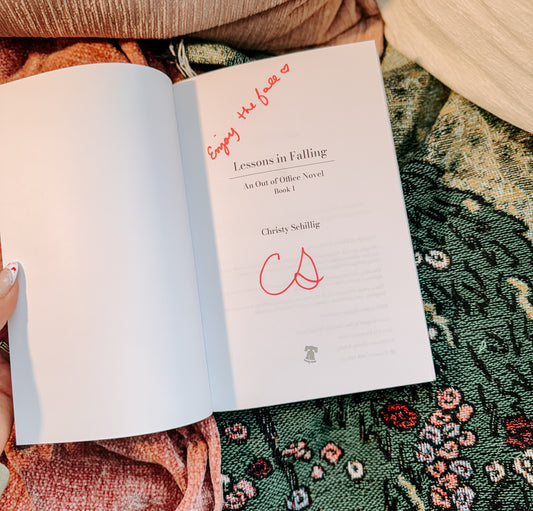 Book titled 'Lessons in Falling' by Christy Schillig on a textured fabric background