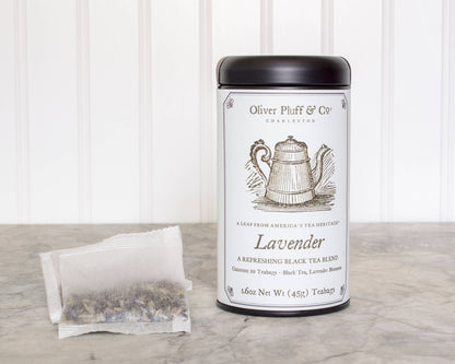 Tea canister labeled 'Oliver Pluff & Co' with a tea bag on a wooden surface. Lavender 