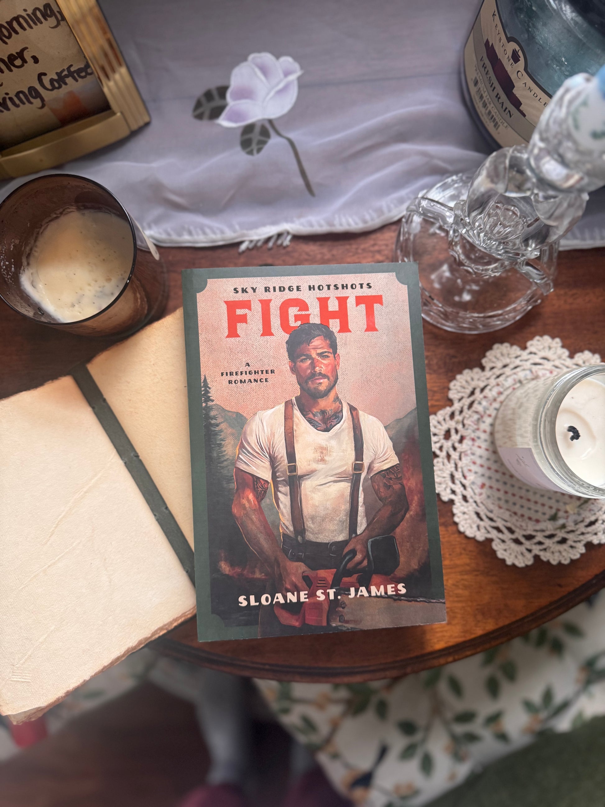 Book titled 'Fight' by Sloane St. James on a table with a bottle and other items.