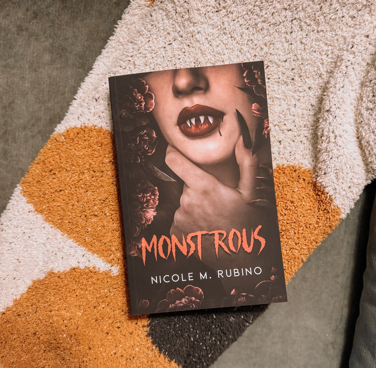 Book titled 'Monstrous' by Nicole M. Rubino on a textured surface