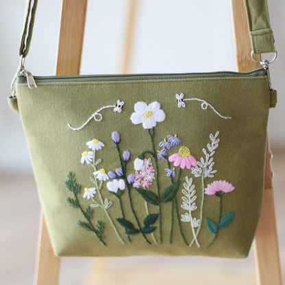 Green handbag with floral embroidery on a wooden chair