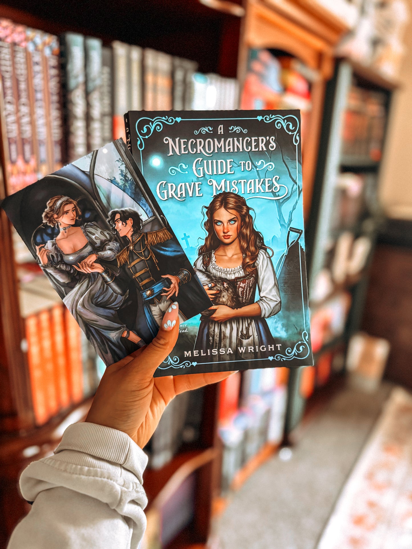 Book titled 'Necromancer's Guide to Grave Mistakes' held in front of a bookshelf.