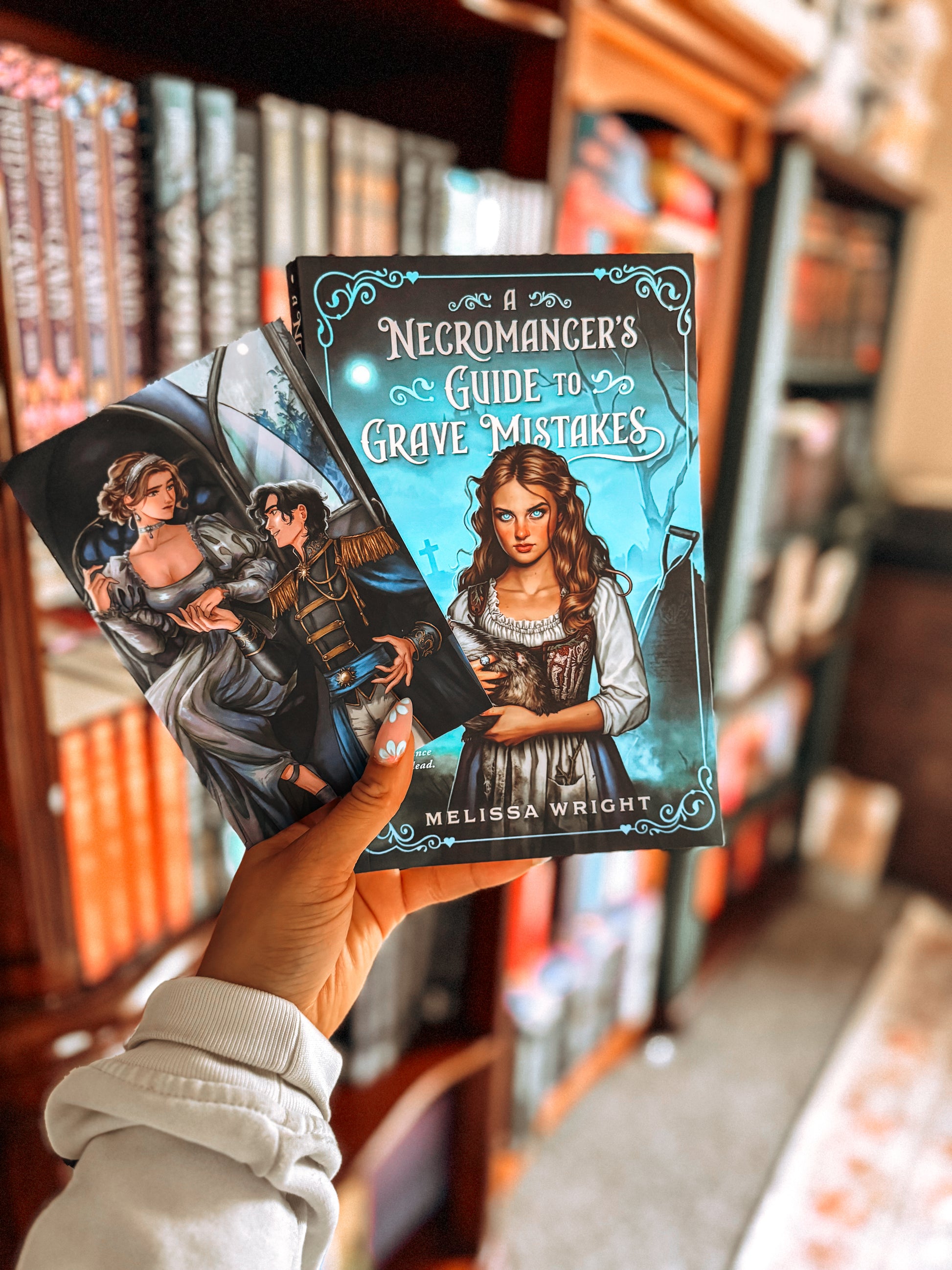 Book titled 'Necromancer's Guide to Grave Mistakes' held in front of a bookshelf.