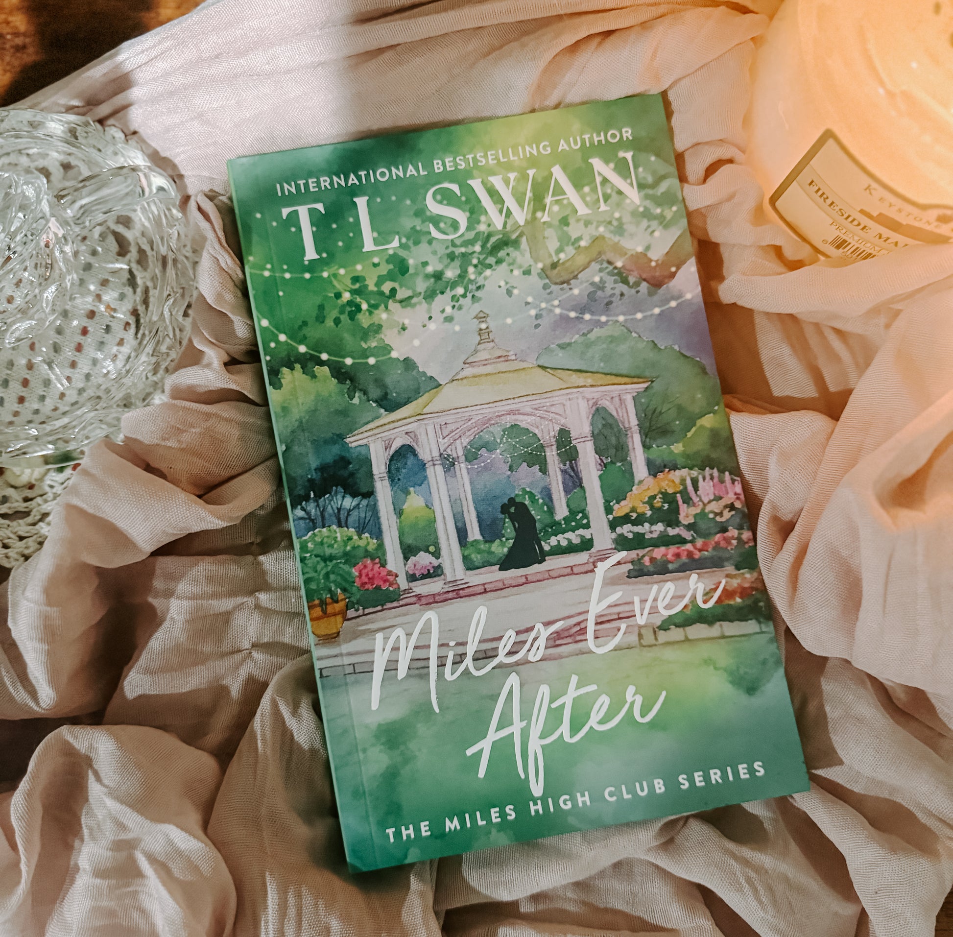 Book titled 'Miles Ever After' by T.L. Swan on a soft fabric background