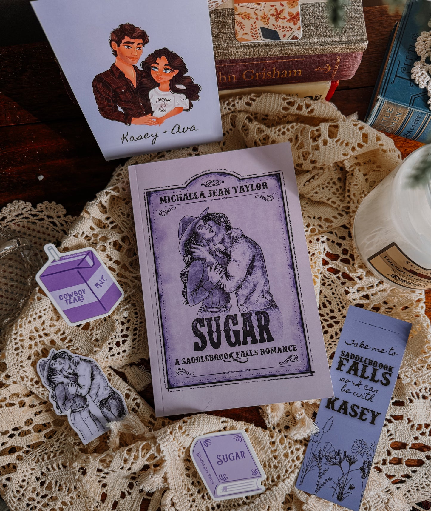 Book titled 'Sugar' by Michaela Jean Taylor with related merchandise on a lace tablecloth.