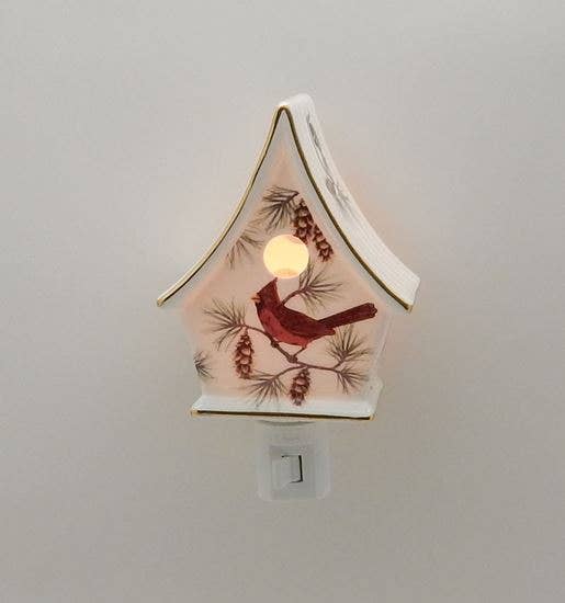 Decorative night light shaped like a birdhouse with a red cardinal design on a plain background
