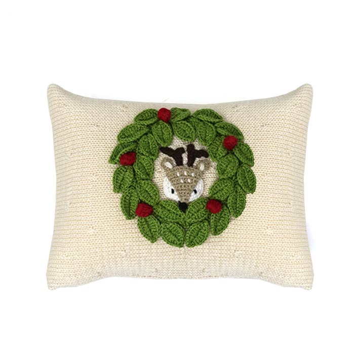 Decorative pillow with a crochet deer  in a wreath design on a white background