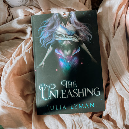 Book titled 'The Unleashing' by Julia Lyman on a textured surface