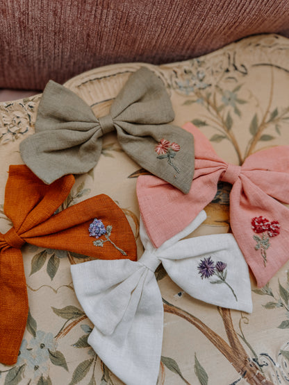 Set of decorative bows with floral embroidery on a patterned surface hair bows 