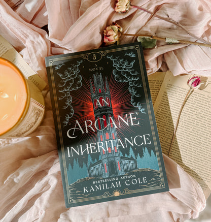 Book titled 'Arcane Inheritance' by Kamilah Cole on a soft fabric background with a candle and flowers.