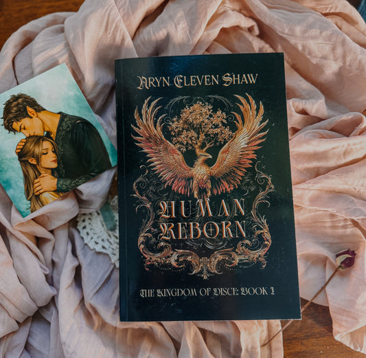 Book titled 'Human Reborn' by Aryn Eleven Shaw on a soft fabric background
