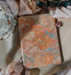 Floral-patterned kindle case  on an open book with a soft focus background