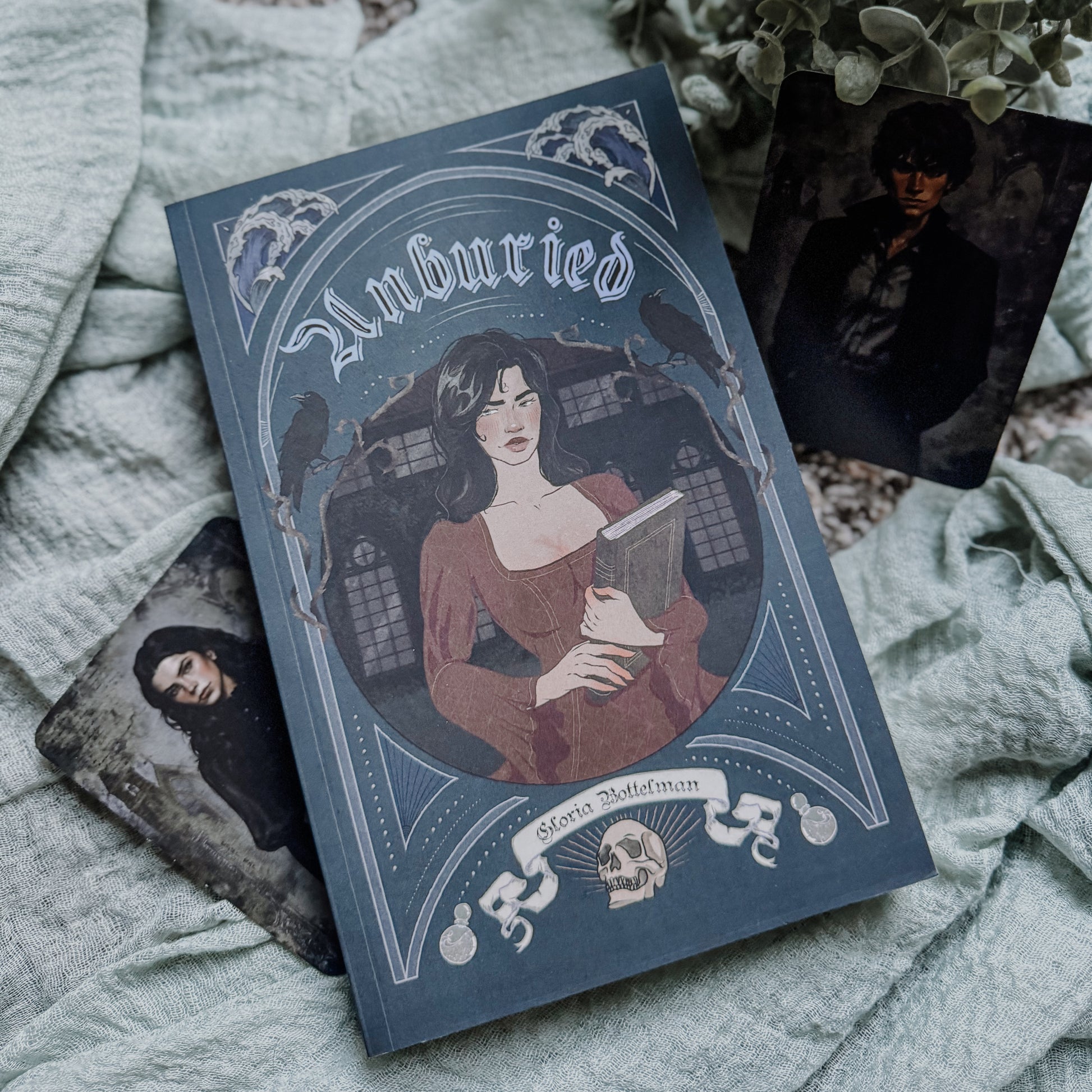 Book titled 'unburied ' with a cover illustration of a woman holding a book, placed on a textured surface.