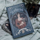 Book titled 'unburied ' with a cover illustration of a woman holding a book, placed on a textured surface.