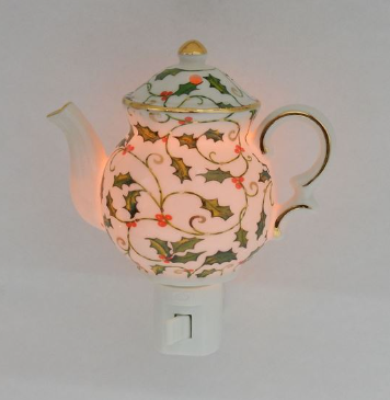 Decorative teapot night light with floral design on a plain background