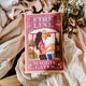 Book titled 'Fire Line' by Maggie Gates on a soft fabric background with flowers.
