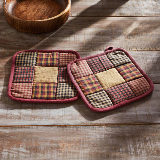 Pair of patchwork potholders on a wooden surface with love , Meena 