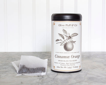 Tea canister labeled 'Cinnamon Orange' by Oliver Pluff & Co on a marble surface with a white background.