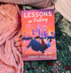 Book titled 'Lessons in Falling' by Christy Schillig on a textured fabric background