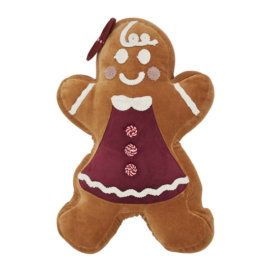 Gingerbread plush toy on a couch with a Christmas tree in the background