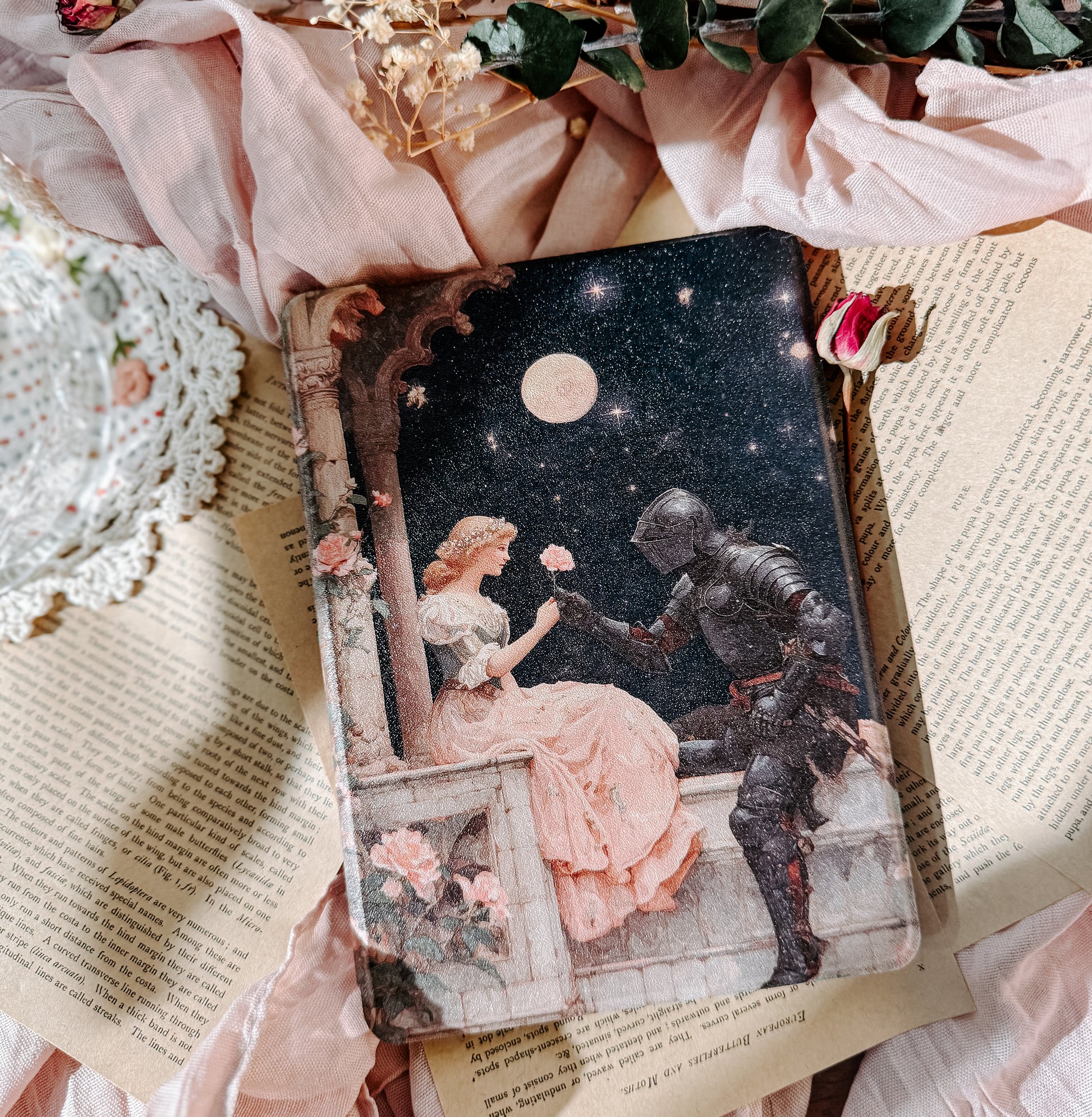 Kindle case  with a romantic illustration of a knight and a lady on a balcony, surrounded by flowers and lace.