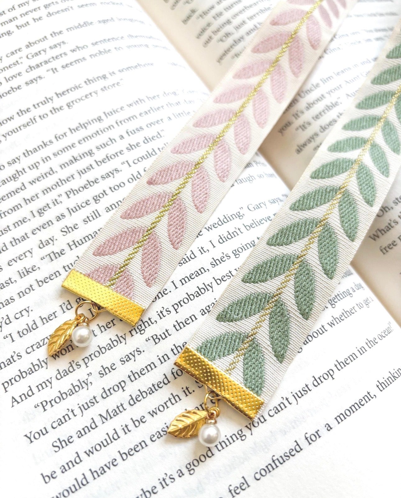 Decorative bookmarks with leaf patterns and gold accents on an open book.