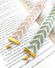Decorative bookmarks with leaf patterns and gold accents on an open book.