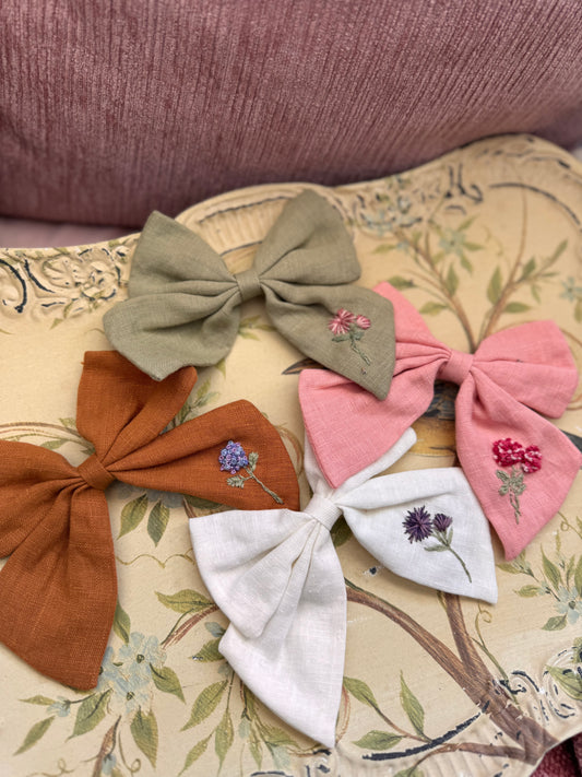 Set of decorative bows with floral embroidery on a patterned surface hair bows 