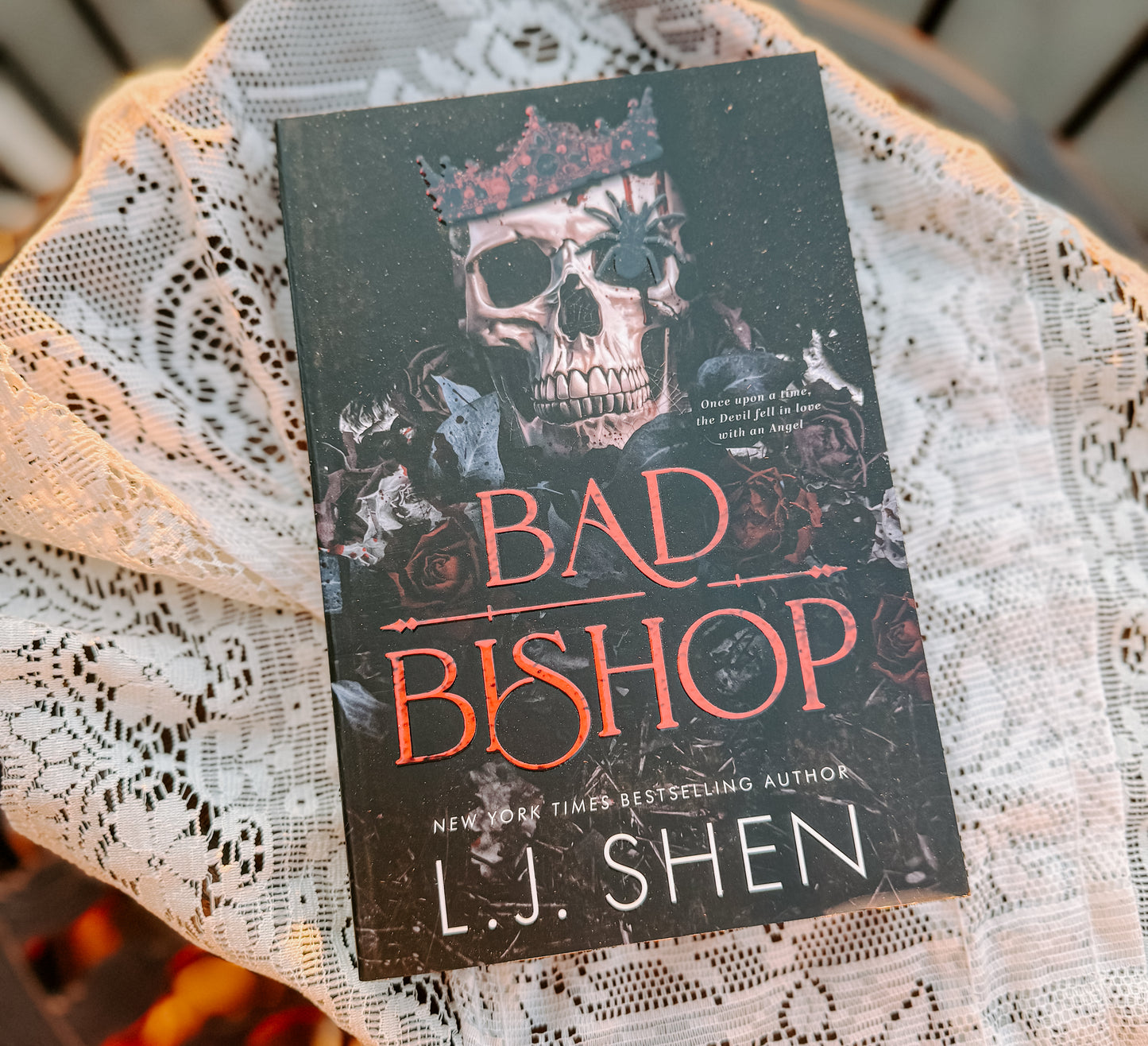 Book titled 'Bad Bishop' by L.J. Shen on a lace surface