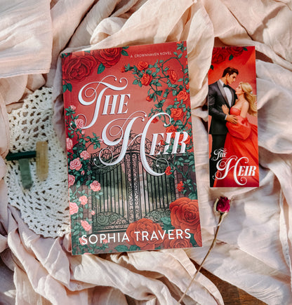 Book titled 'The Heir' by Sophia Travers on a decorative surface with roses.
