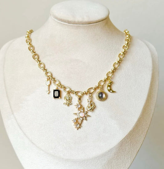 Gold necklace with charms on a card titled 'A Court of Thorns and Roses'.