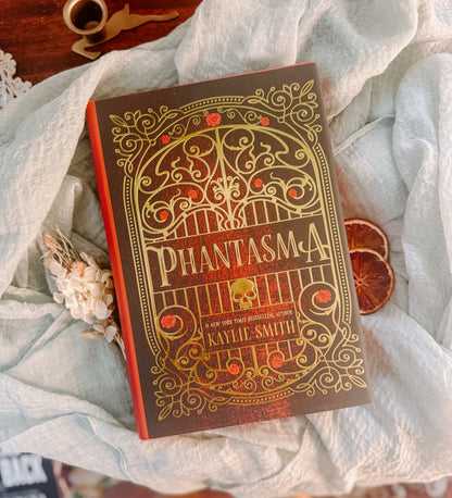 Book titled 'Phantasma' by Kaylie Smith on a textured surface with decorative elements. Deluxe limited edition 