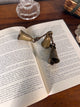 Open book with a vintage bell on a wooden surface