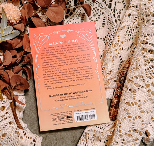 Book titled 'A Match Made in Hell' by Charlotte Ingham on a textured surface with decorative elements.