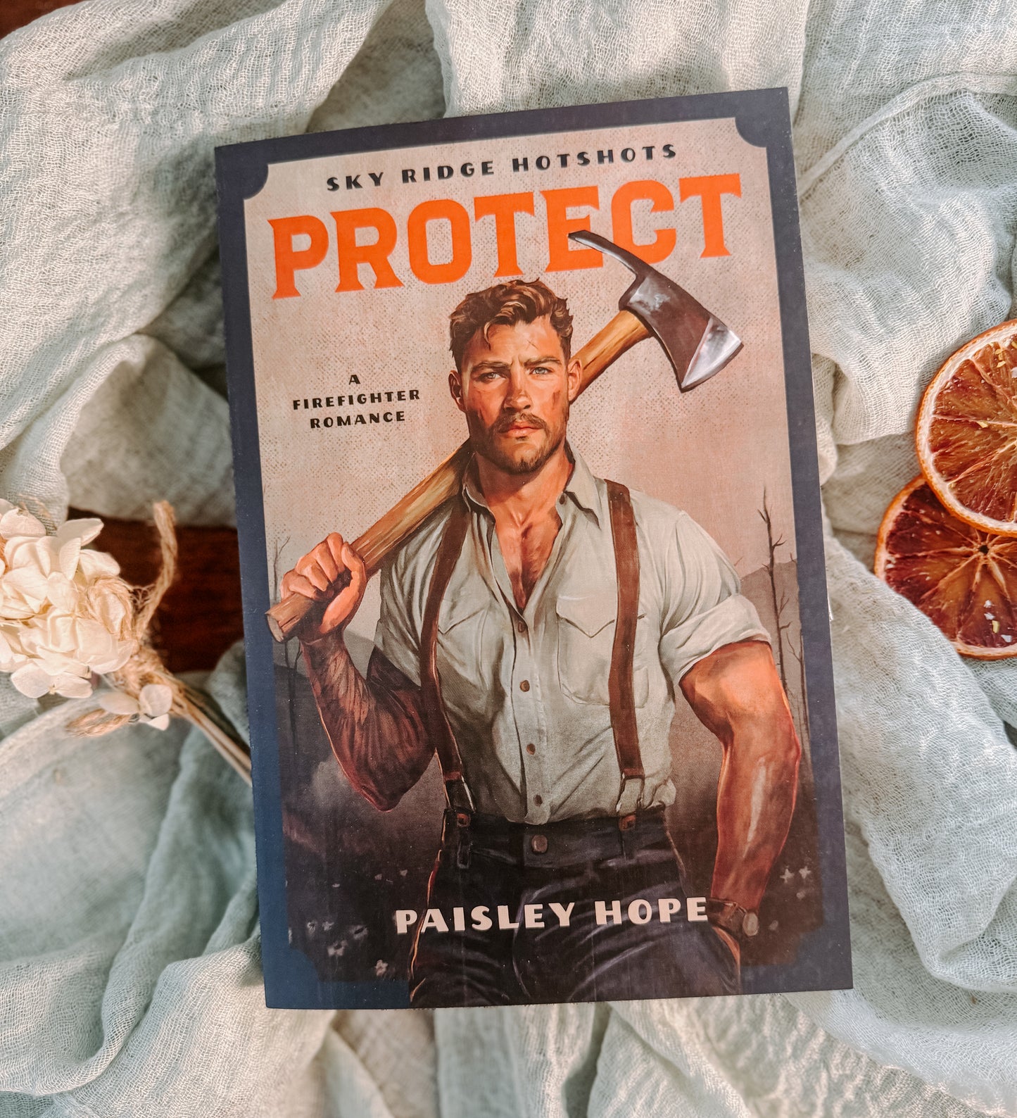 Book cover of 'PROTECT' by Paisley Hope with a firefighter holding an axe on a textured fabric background.