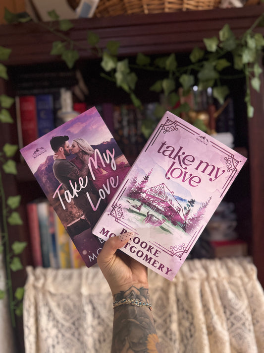 Two books titled 'Take My Love' held in front of a bookshelf.