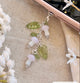 Decorative charm with mushrooms and leaves on a textured surface with flowers.