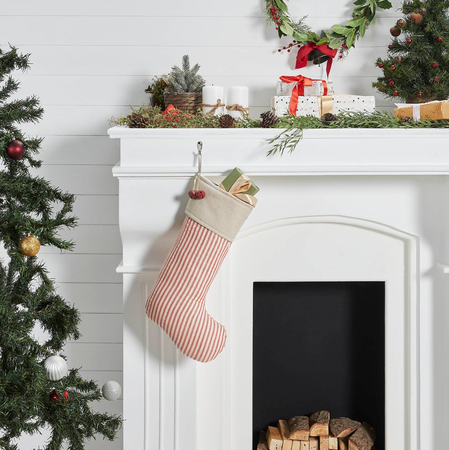 Christmas stocking hanging on a white fireplace with decorative elements.